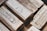 A collection of silver bullion bars, intricately engraved with various inscriptions, stamps, and symbols, stacked closely together. The bars have a reflective surface and display a rich metallic texture.