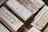 A collection of silver bullion bars, intricately engraved with various inscriptions, stamps, and symbols, stacked closely together. The bars have a reflective surface and display a rich metallic texture.
