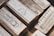 A collection of silver bullion bars, intricately engraved with various inscriptions, stamps, and symbols, stacked closely together. The bars have a reflective surface and display a rich metallic texture.