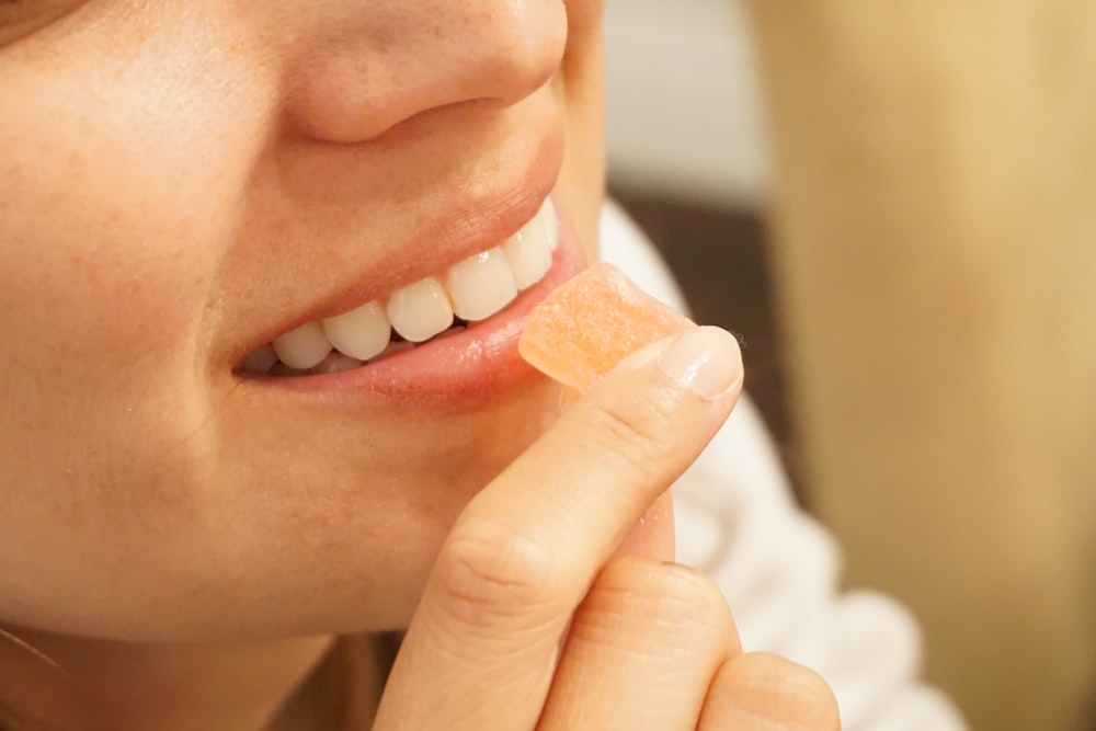 femme tenant des bonbons orange et blanc