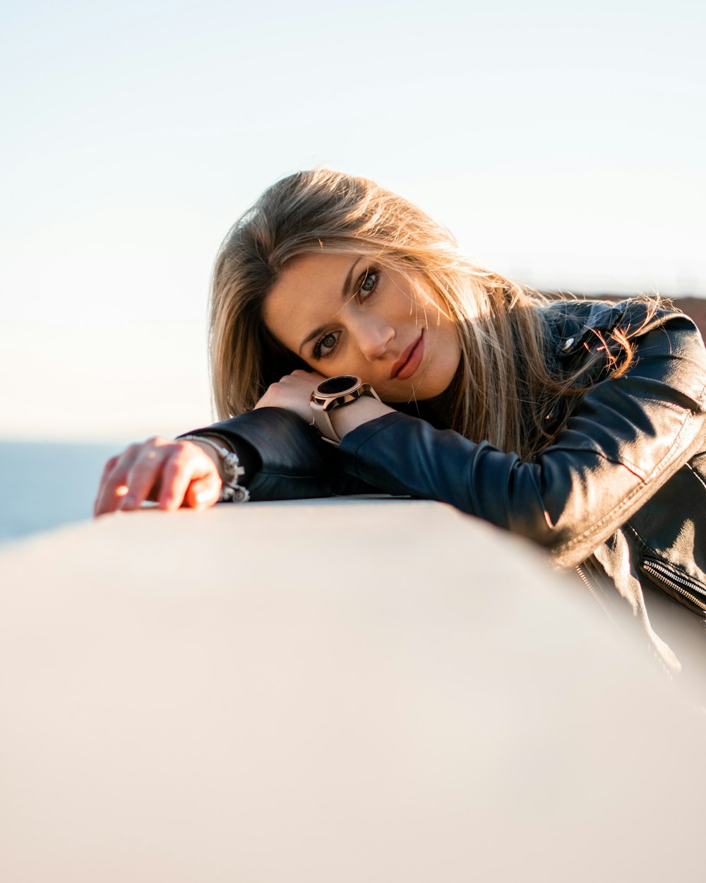 woman in black and white jacket lying on white boat during daytime