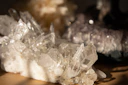 A sleek display of clear quartz points with shimmering cosmic light effects on dark background