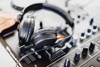 black and gray corded headphones on black and gray audio mixer