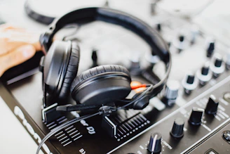 Close-up of headphones resting on a black and gold audio mixer.