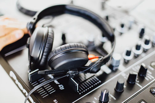 Close-up of headphones resting on a black and gold audio mixer.