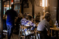 Happy diners enjoying their meals in a cozy, softly lit dining room.
