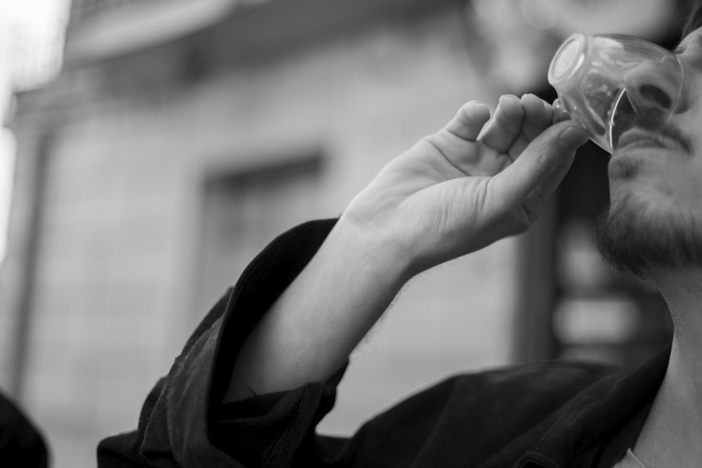 grayscale photo of person holding round ornament