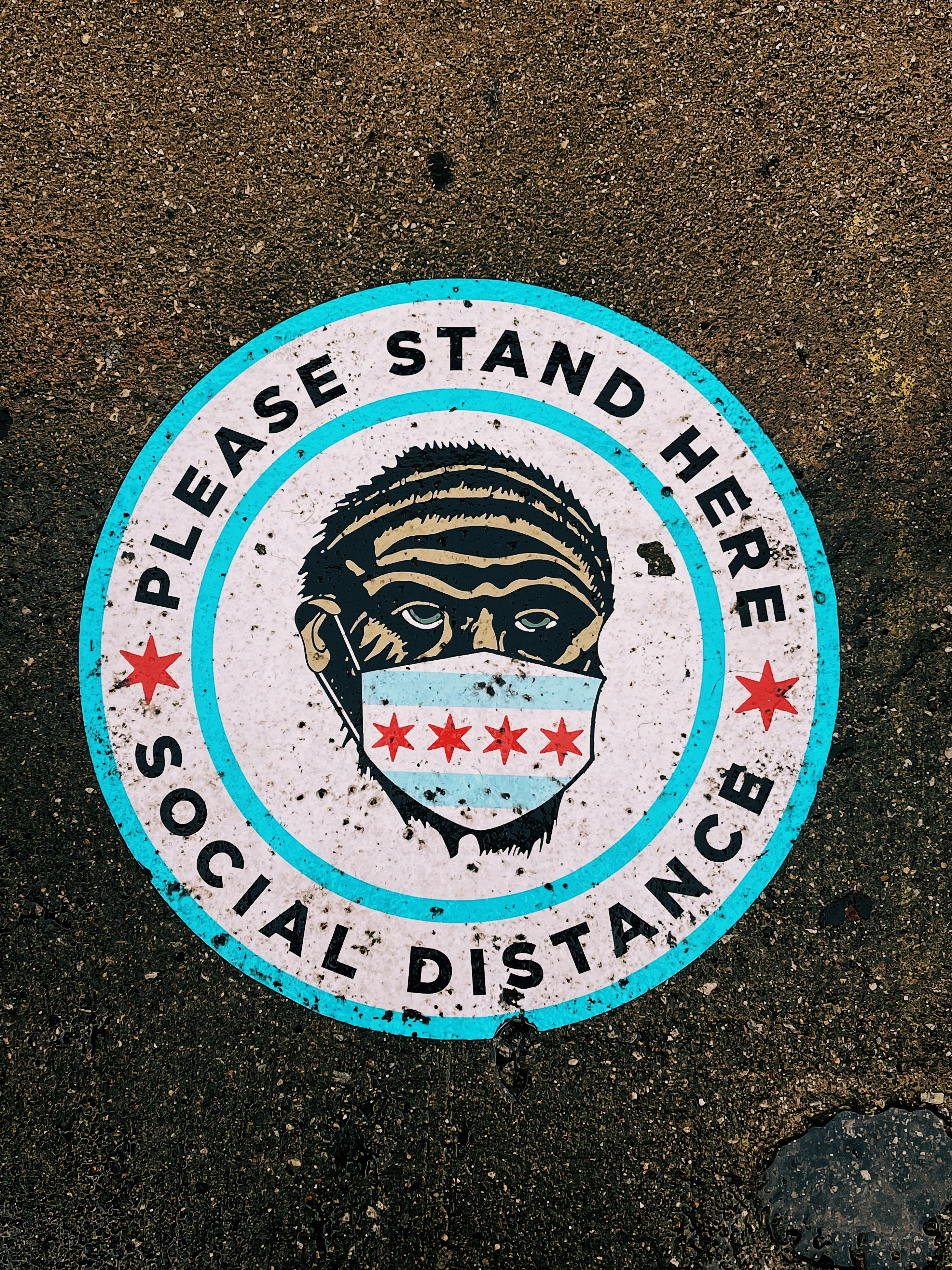 un panneau bleu et blanc qui dit s’il vous plaît tenez-vous ici distance sociale