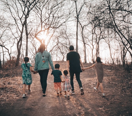 Family walking through the woods down a dirt path