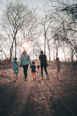 group of people standing on brown dirt road during daytime