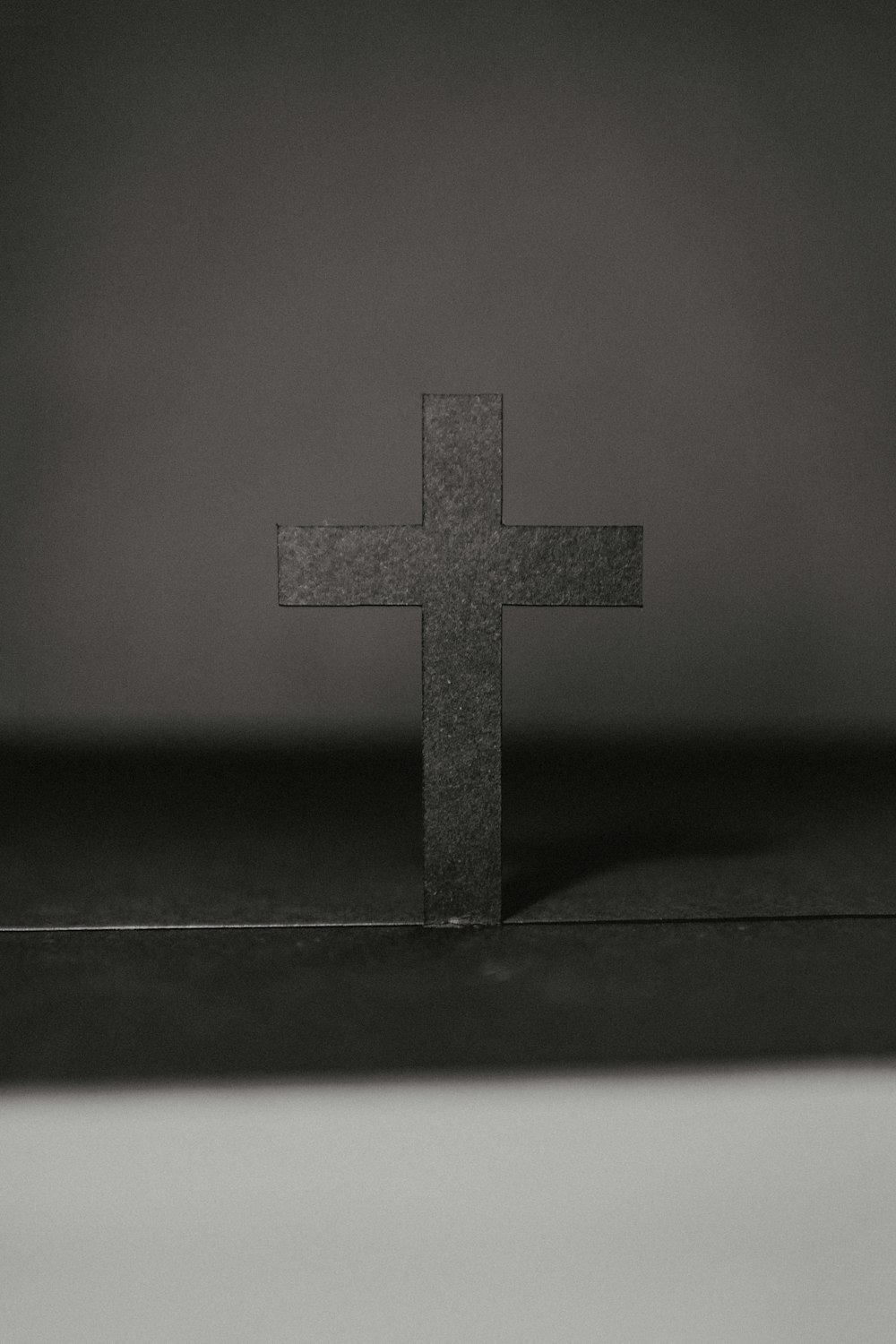 grayscale photo of cross on table