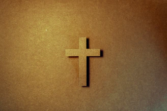 Close-up of a hand-painted Christian symbol on textured canvas with warm lighting.