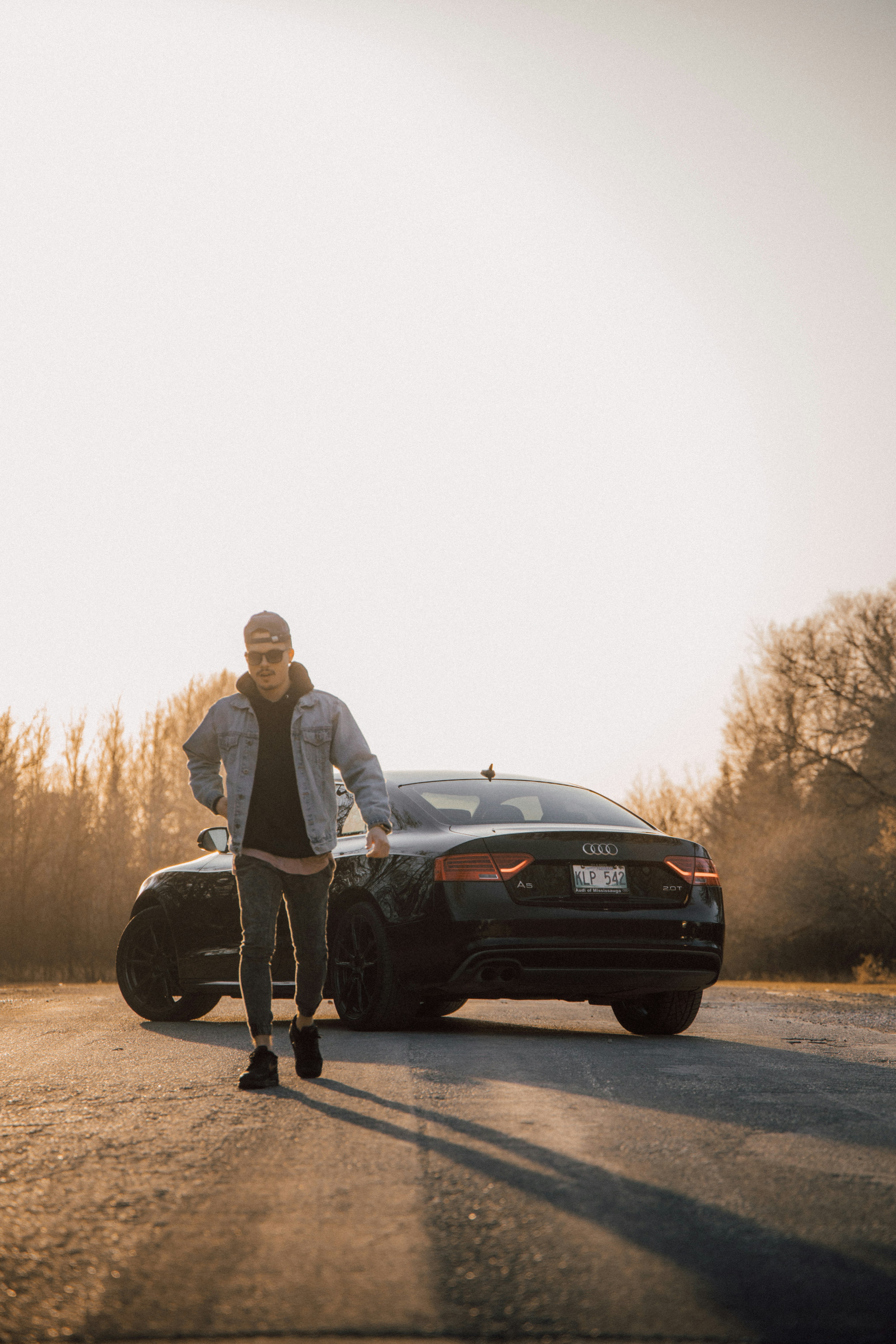 man and woman standing beside black car during daytime