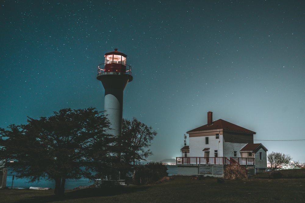 white and red lighthouse under blue sky during night time