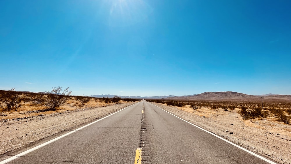 gray concrete road under blue sky during daytime