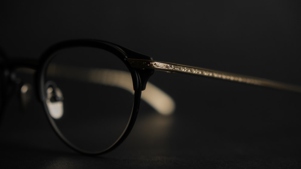 black framed eyeglasses on black surface