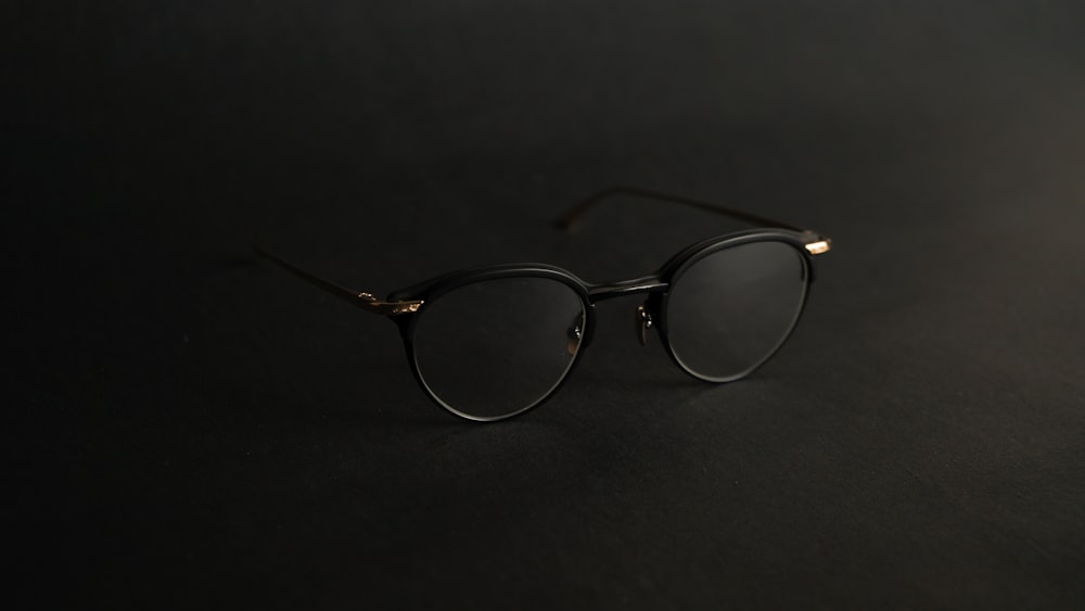 gafas con montura plateada sobre superficie negra