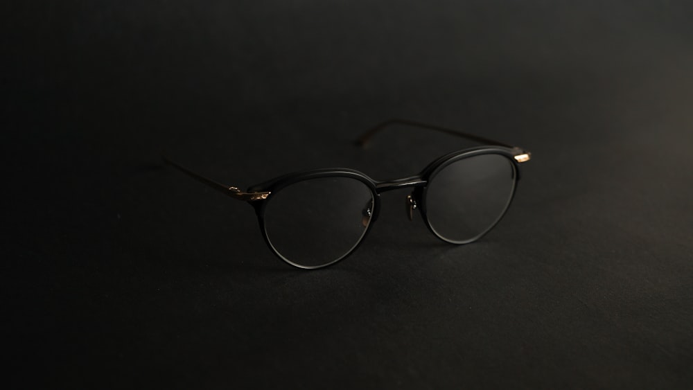 silver framed eyeglasses on black surface