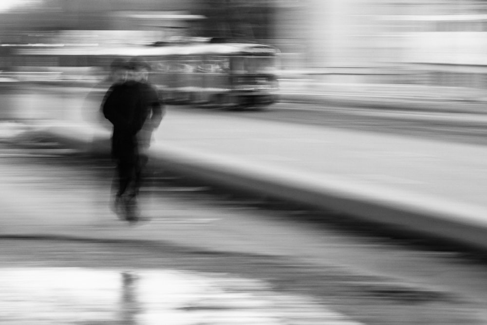 거리를 걷는 남자의 그레이스케일 사진