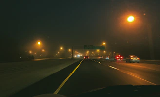 A nighttime highway scene with multiple cars featuring bright, crisp LED headlights.