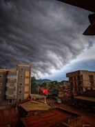 A dramatic sky filled with dark storm clouds rolling over a quiet town.