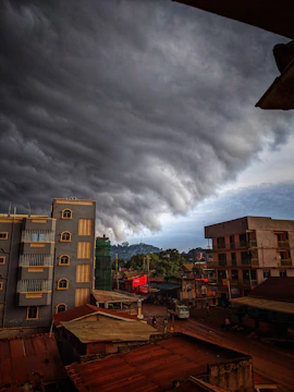 A dramatic sky filled with dark storm clouds rolling over a quiet town.