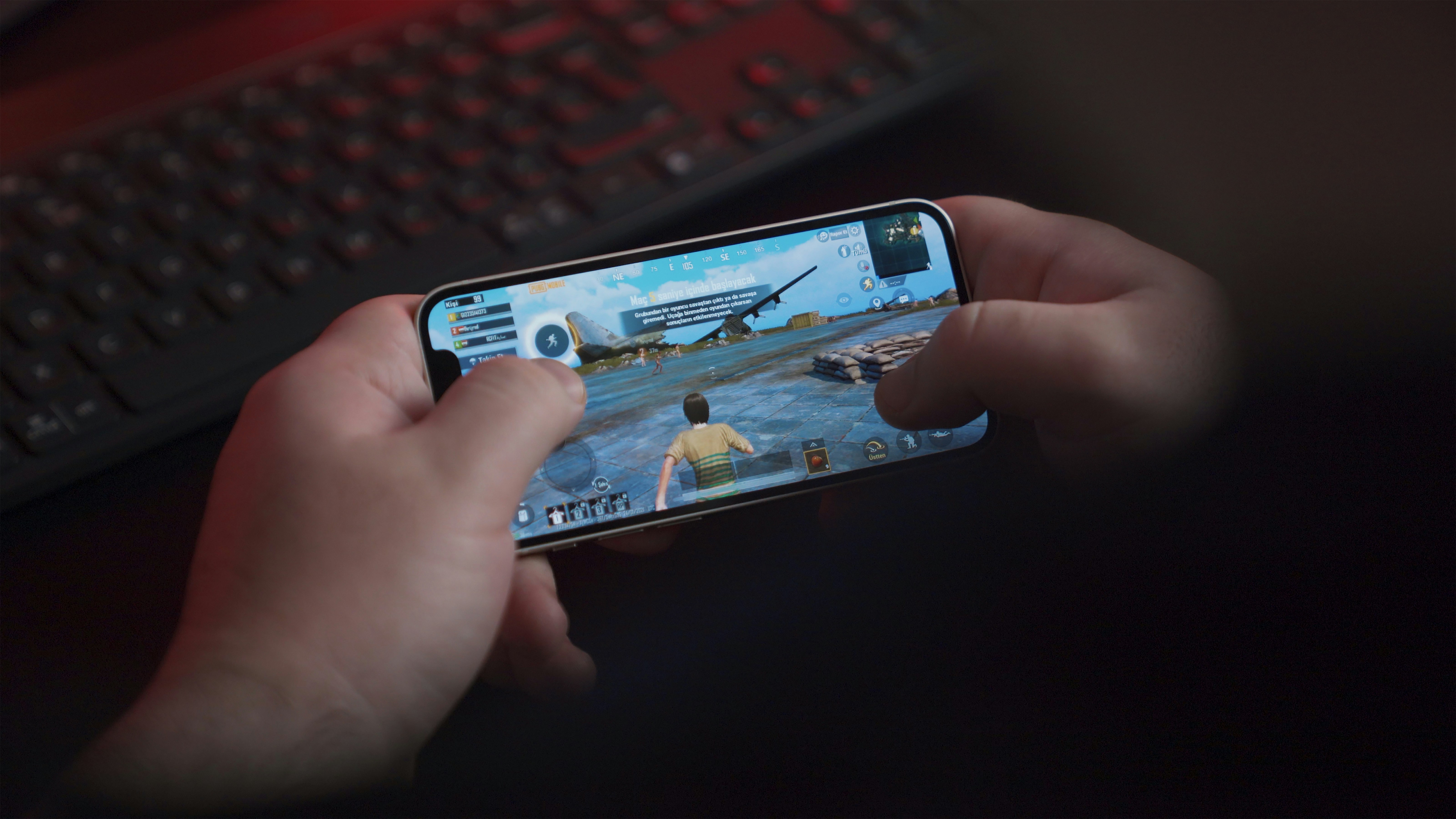 Young man playing PUBG Mobile with iPhone
