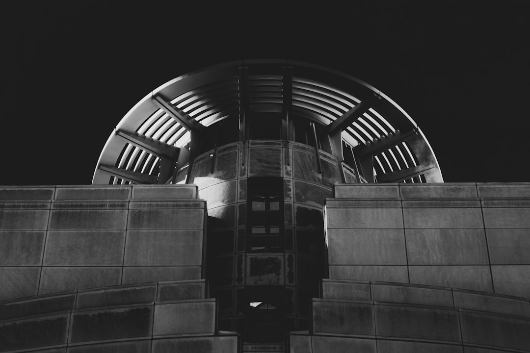 grayscale photo of building with glass windows