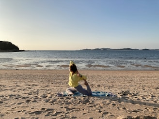 woman in yellow dress sitting on beach shore during daytime