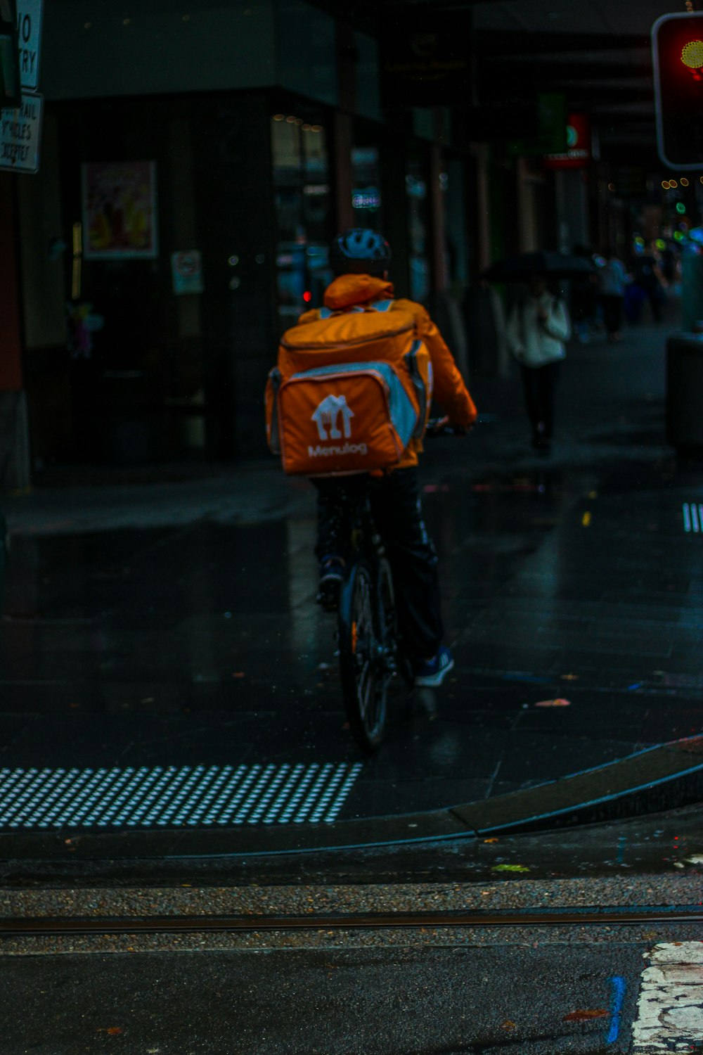 a man riding a bike down a street next to a traffic light