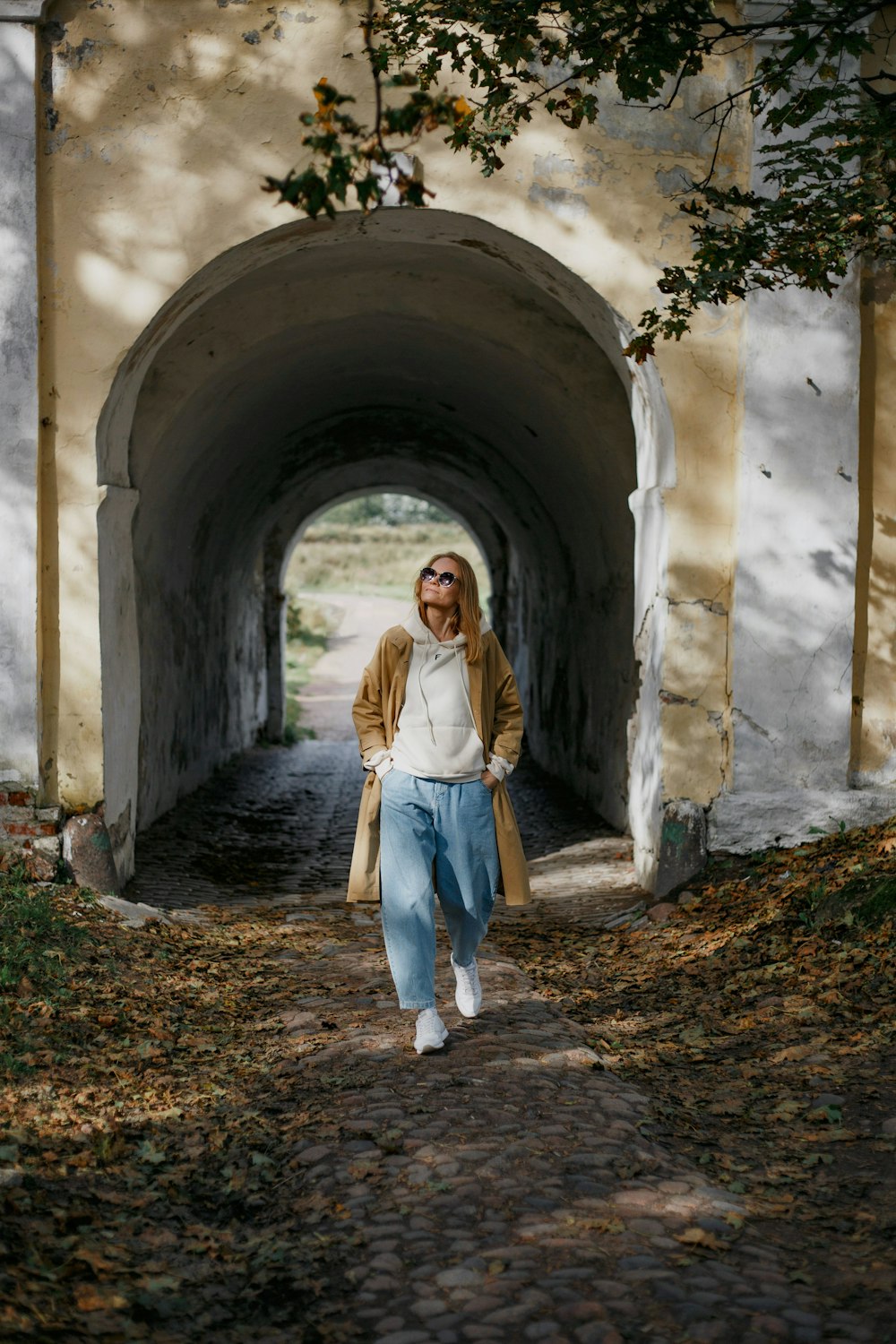 woman in white long sleeve dress standing on tunnel during daytime