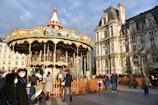 A joyful group of diverse people gathered around a solar-powered carousel.