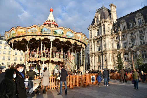 A joyful group of diverse people gathered around a solar-powered carousel.
