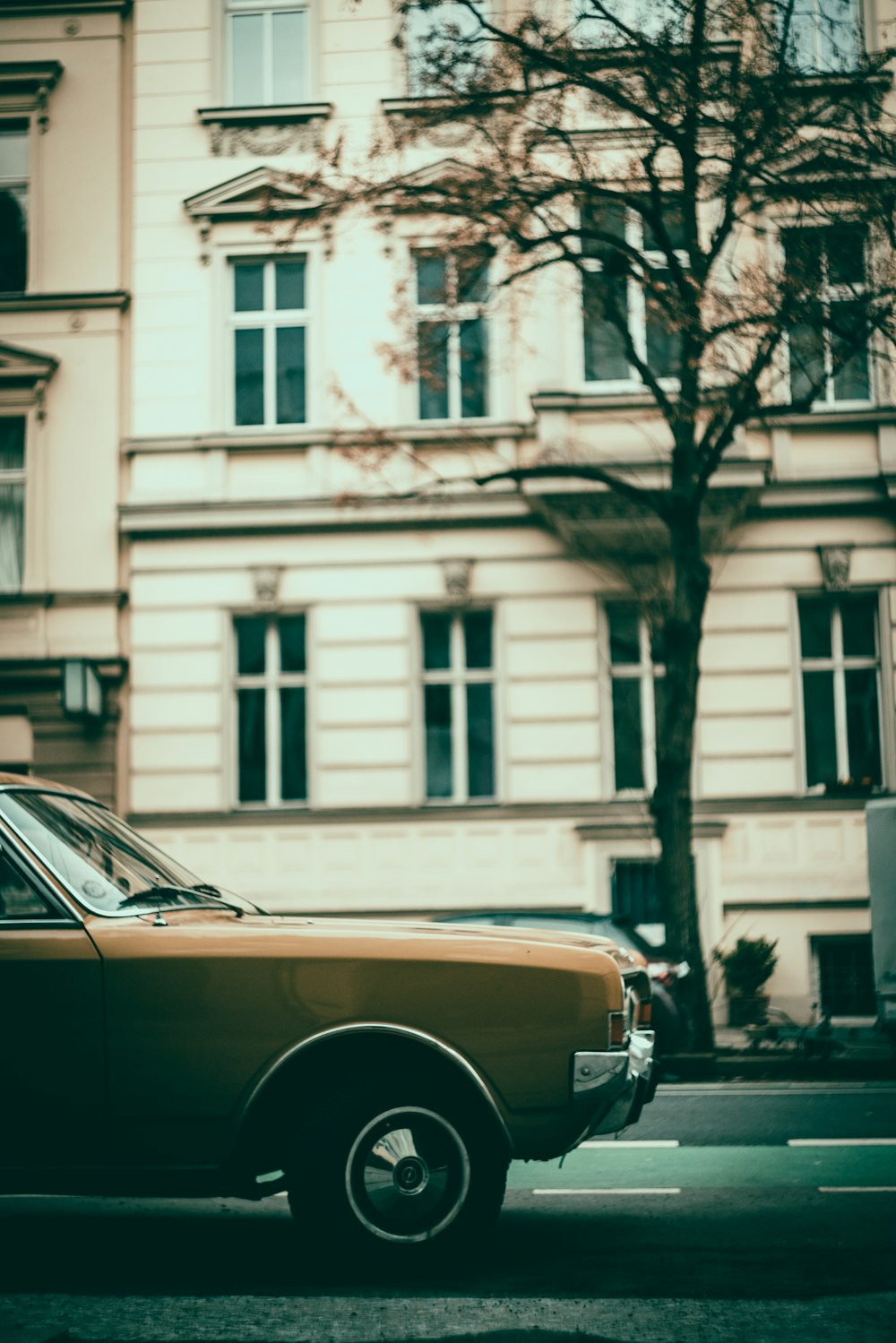 brown car parked beside white building during daytime