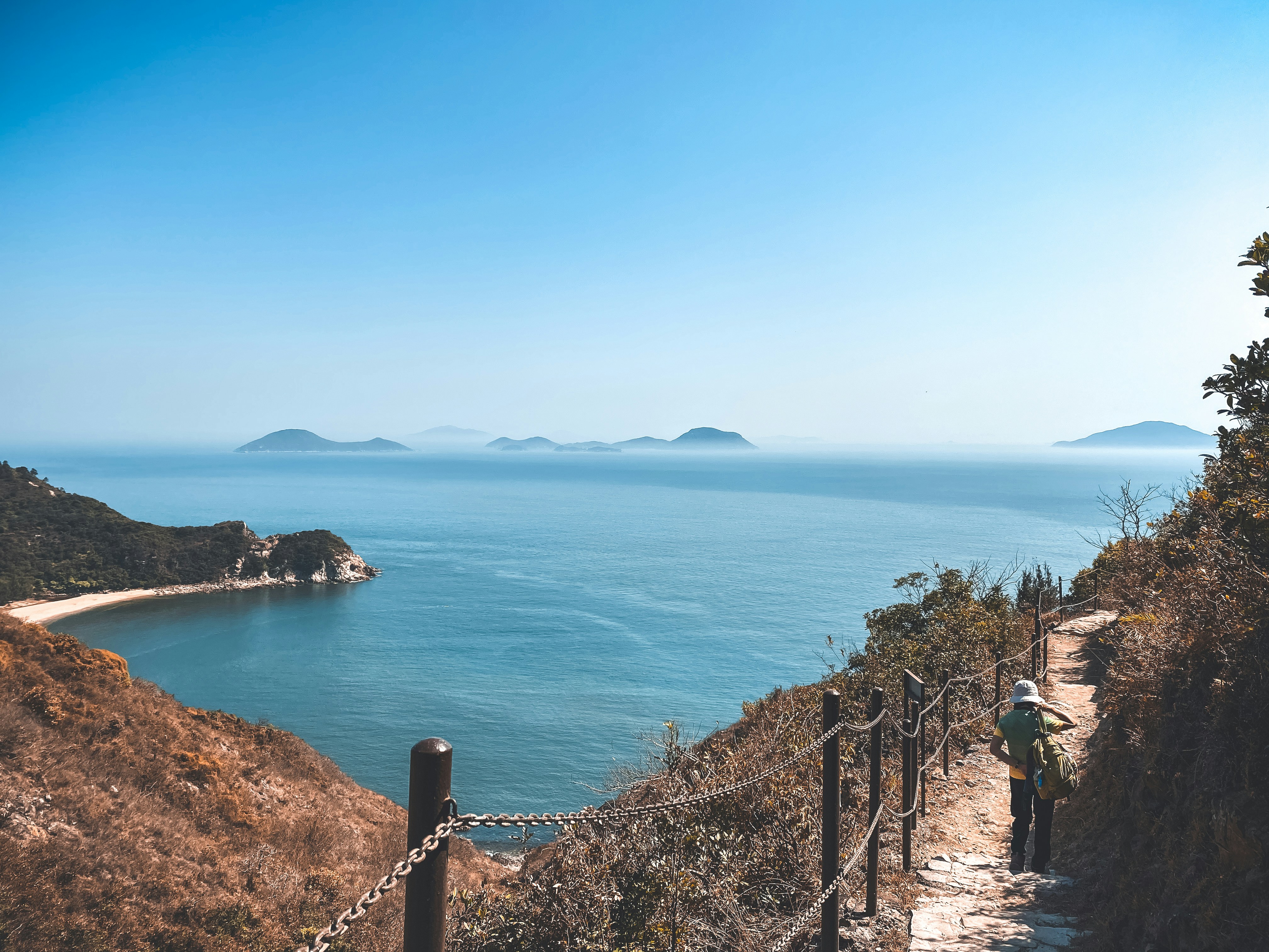 Menschen, die tagsüber auf einem Weg in der Nähe des Meeres spazieren gehen