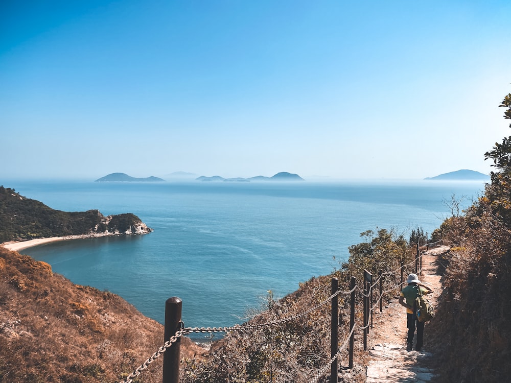 people walking on pathway near sea during daytime