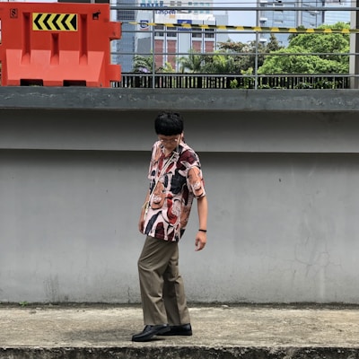 man in brown pants standing near red and white building during daytime