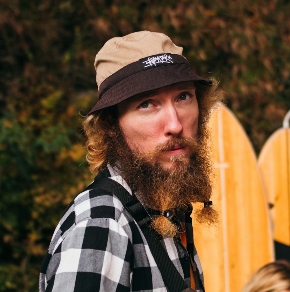 man in white and black checkered dress shirt wearing brown hat