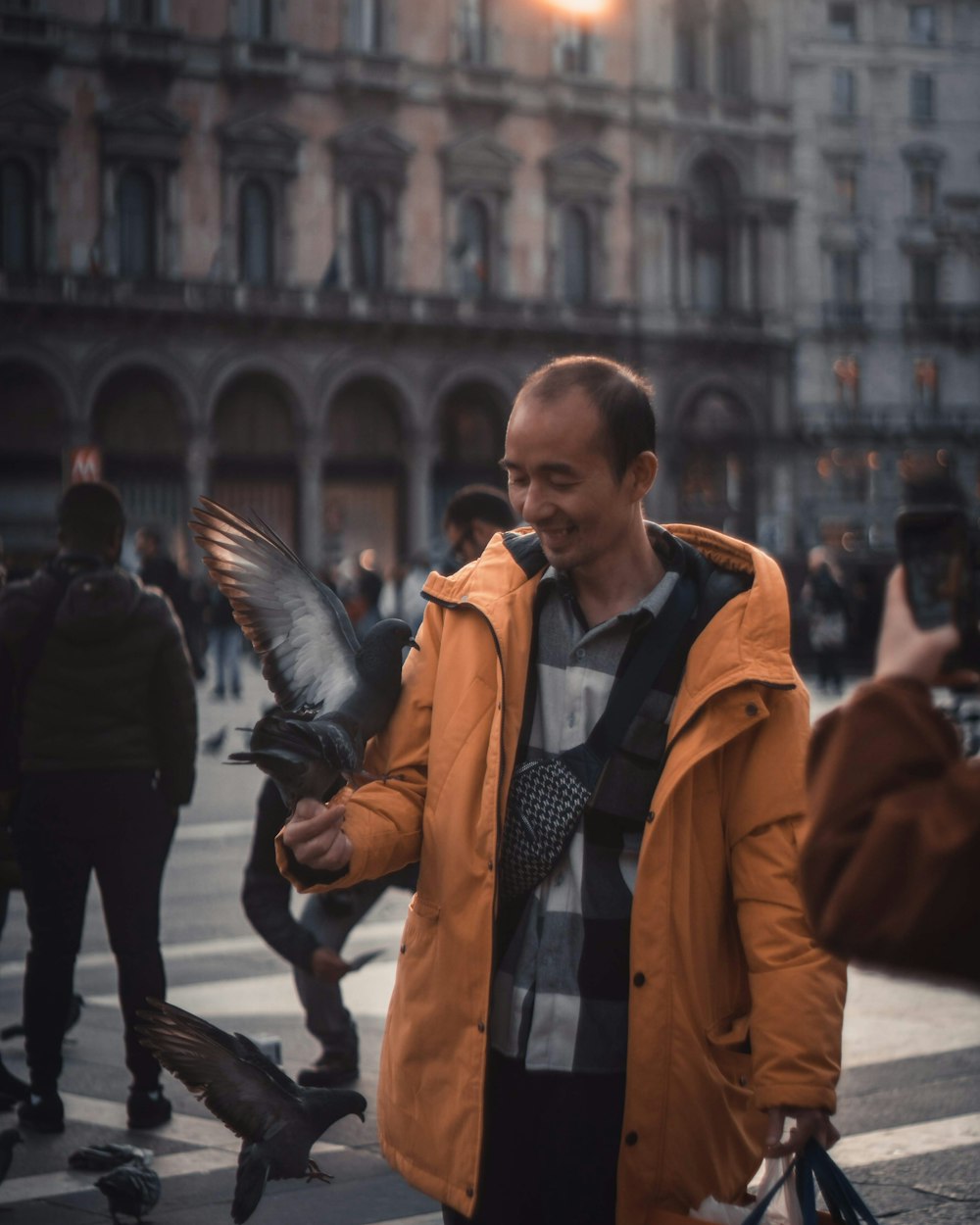 man in brown coat standing on street during daytime