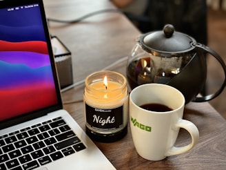 A cozy gaming setup with a laptop displaying colorful slot demo games and a cup of coffee nearby.