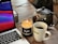 An inviting image of a cozy home office setup with a laptop and a cup of tea.