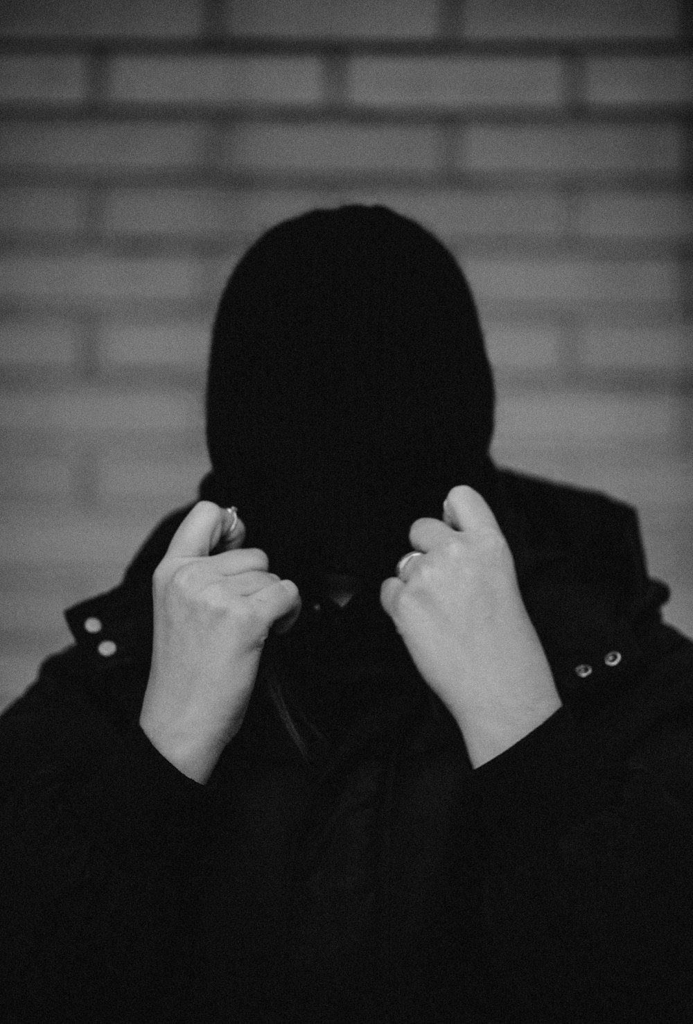 grayscale photo of person covering face with knit cap