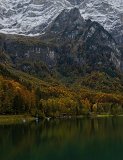 A tranquil lake reflecting autumn-colored trees in a remote mountain valley.