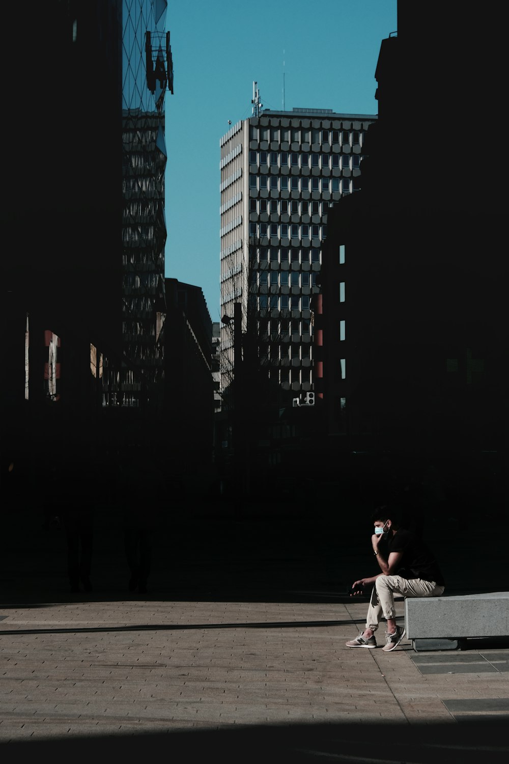 woman in white dress sitting on concrete bench during night time