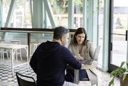man in black long sleeve shirt sitting on chair beside woman in black and white stripe