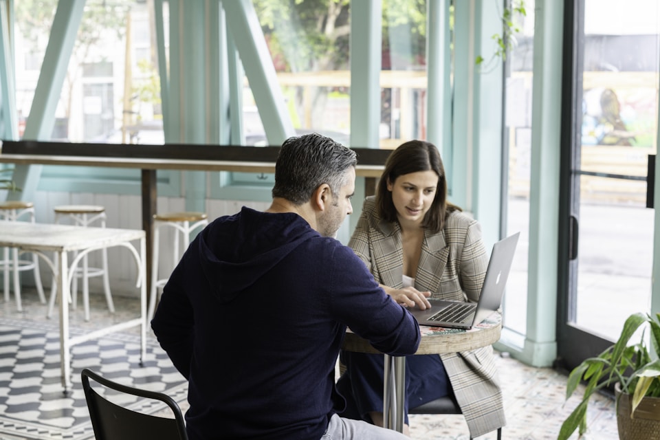 Business owner meeting with a web design consultant to discuss website and local SEO strategies.