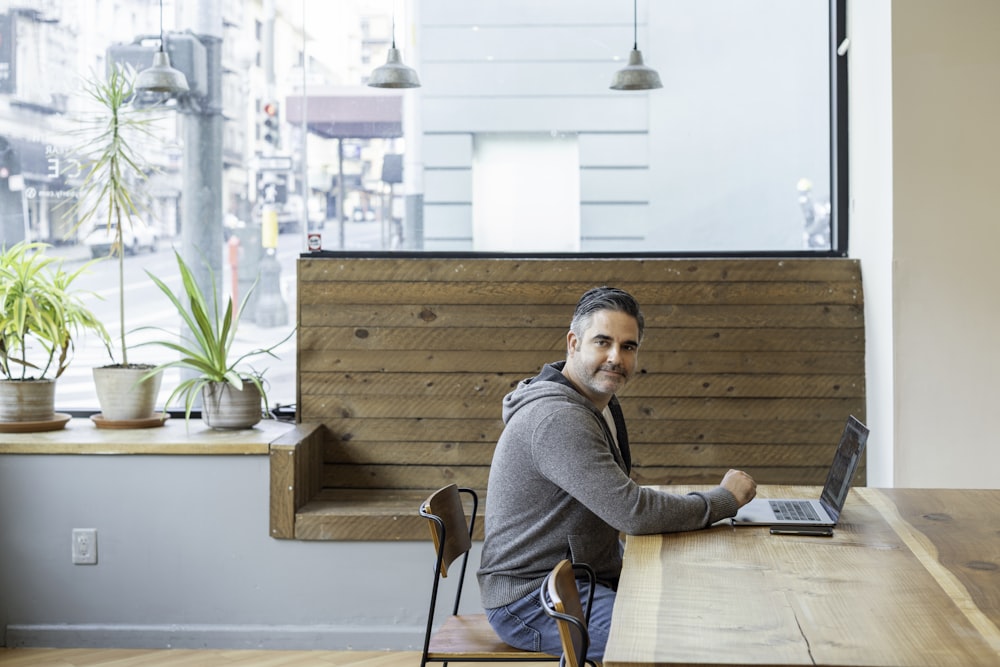 man in gray sweater sitting on chair