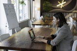 woman in gray and white striped long sleeve shirt using silver macbook