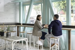 man and woman sitting on white chair