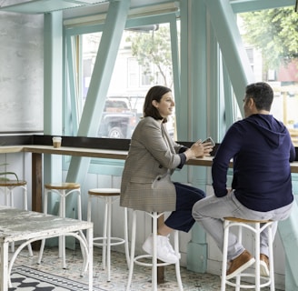 man and woman sitting on white chair